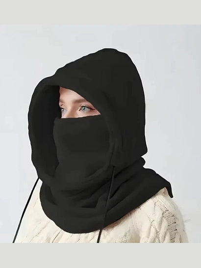 Person wearing a black hooded garment against a plain background