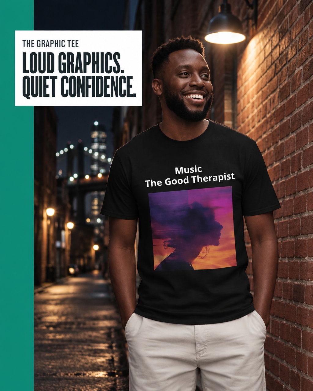 A man wearing a black graphic t-shirt with the text 'Music The Good Therapist' and a colorful sunset silhouette print, standing in a brick alley at night. A white text box in the top left reads 'THE GRAPHIC TEE LOUD GRAPHICS, QUIET CONFIDENCE.